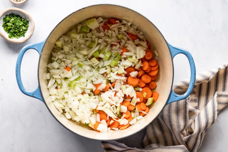 Dutch oven with onion, celery, and carrots.