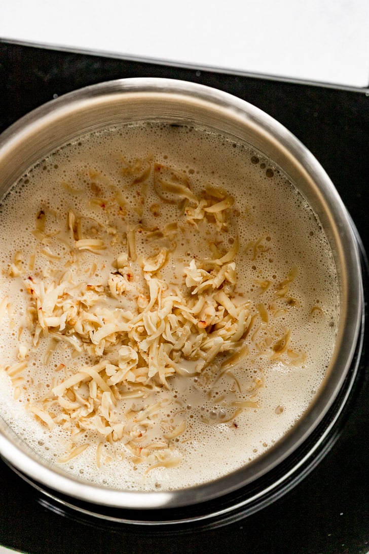 saucepan with shredded cheese added.