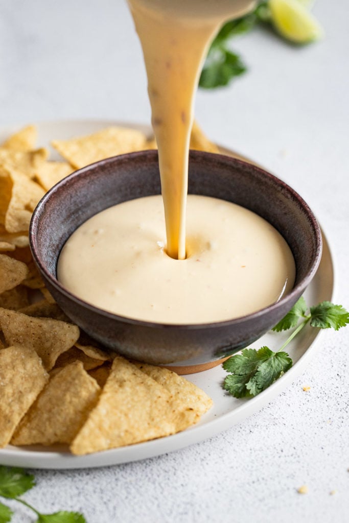Queso pouring into bowl.