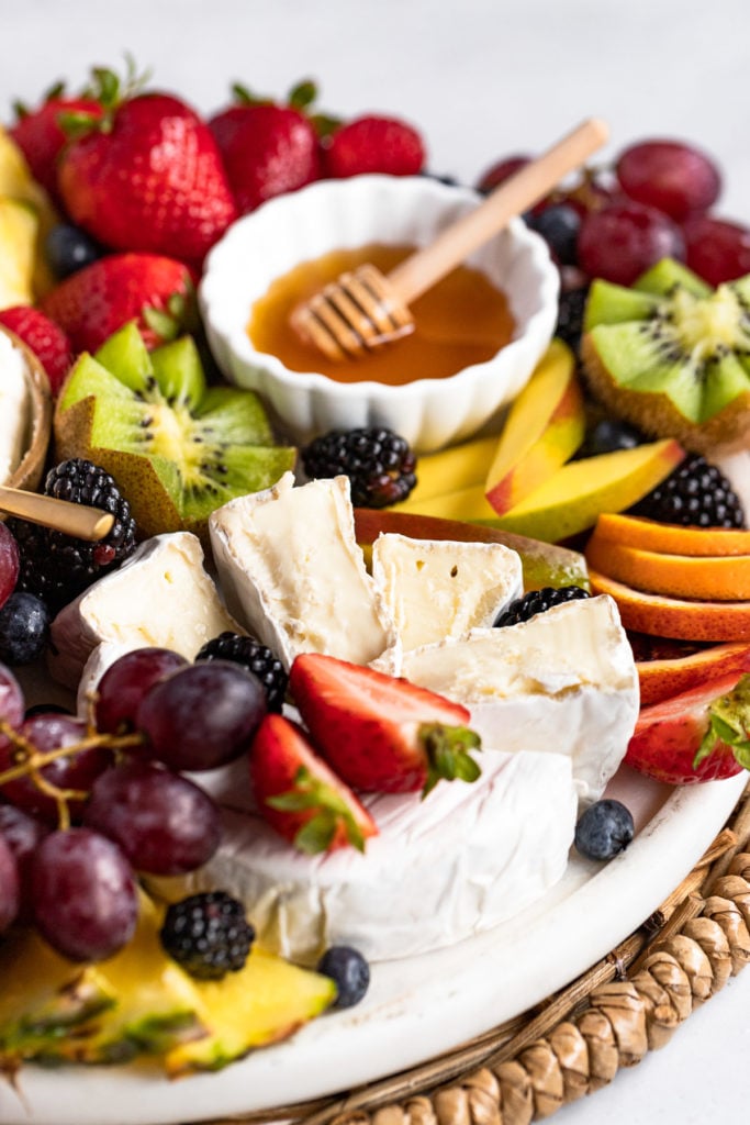 Brie wedges on fruit board.