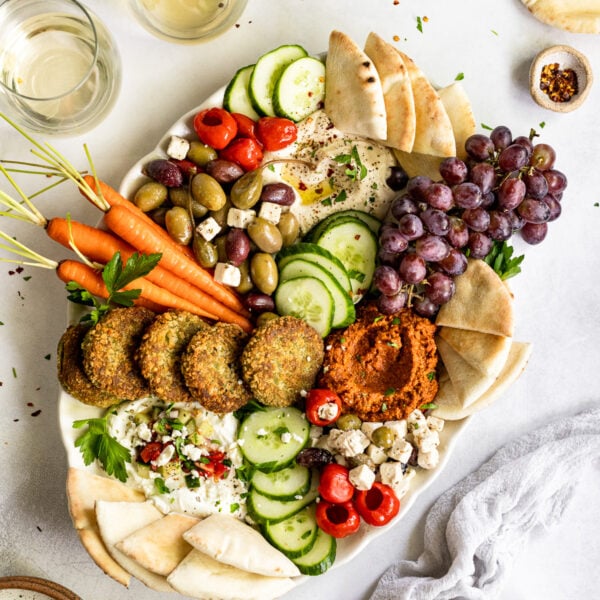 Mediterranean cheese board with wine glasses and pita.