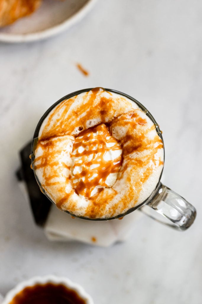 Overhead caramel latte with whipped cream and caramel drizzle.