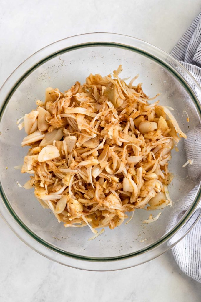Shredded jackfruit tossed with spices in a bowl.