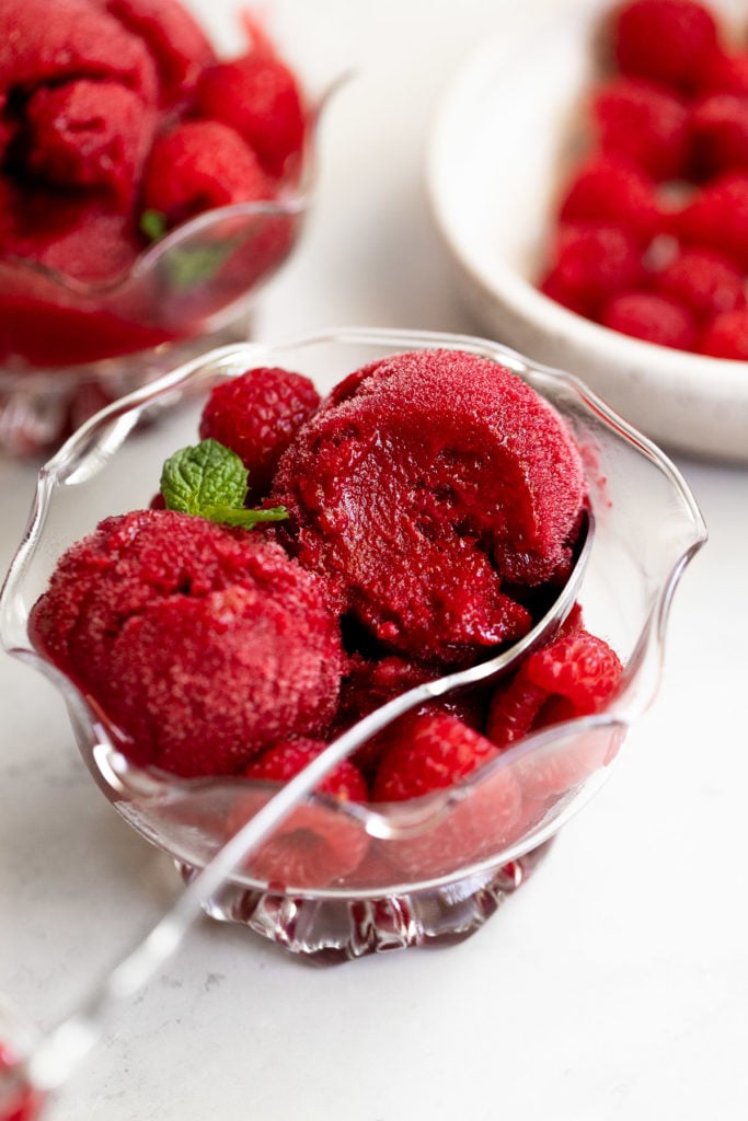 Bite out of raspberry sorbet in bowl.