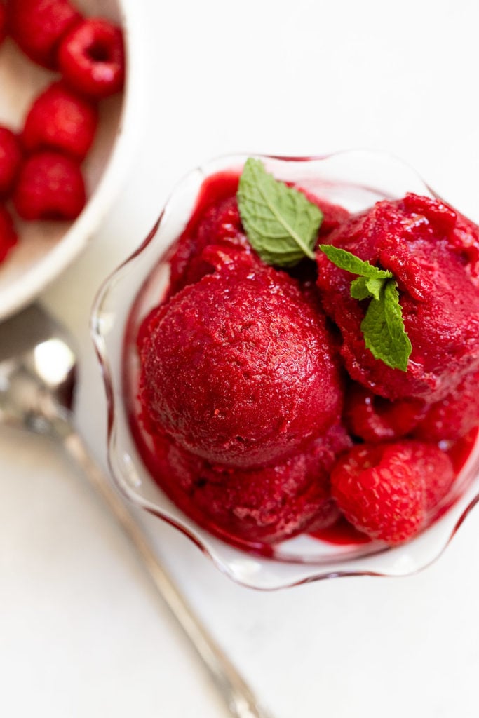 Overhead raspberry sorbet with mint leaves.