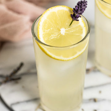 Glass of lavender lemonade with garnishes.
