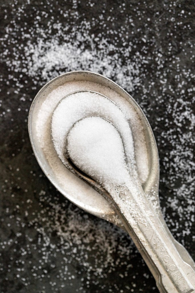Table salt in measure spoons.