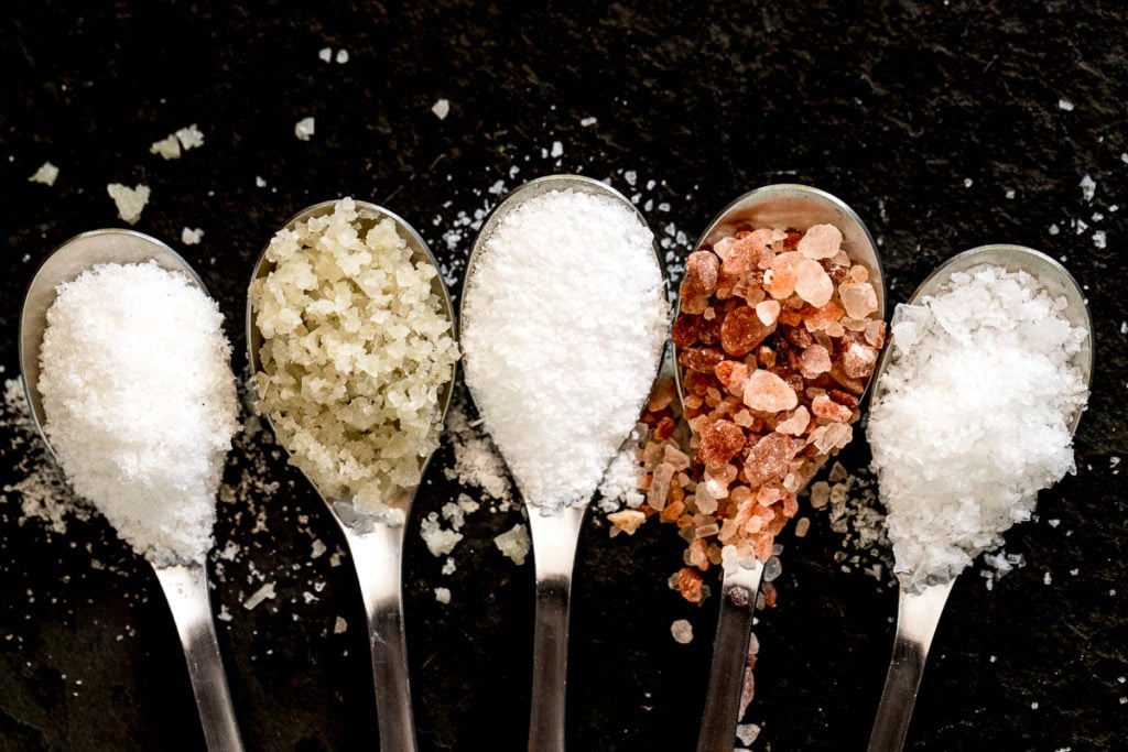 Five spoons with different salts.
