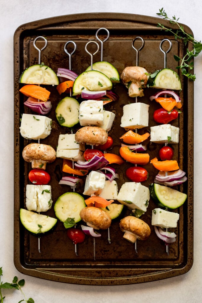 Halloumi skewers before grilling on pan.