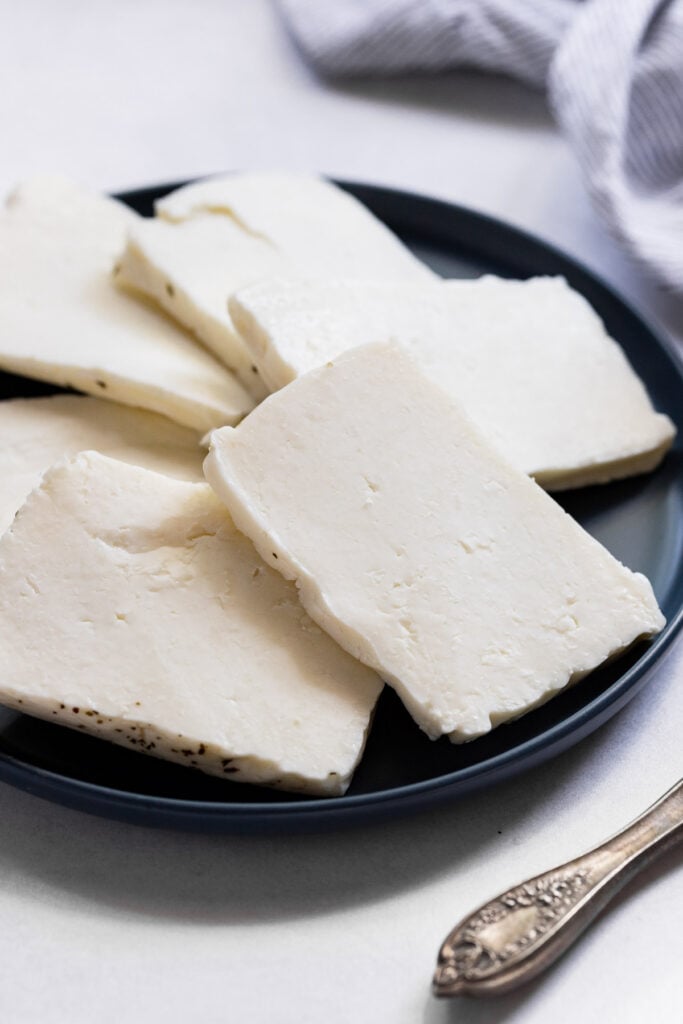Slices of halloumi on plate before cooking.