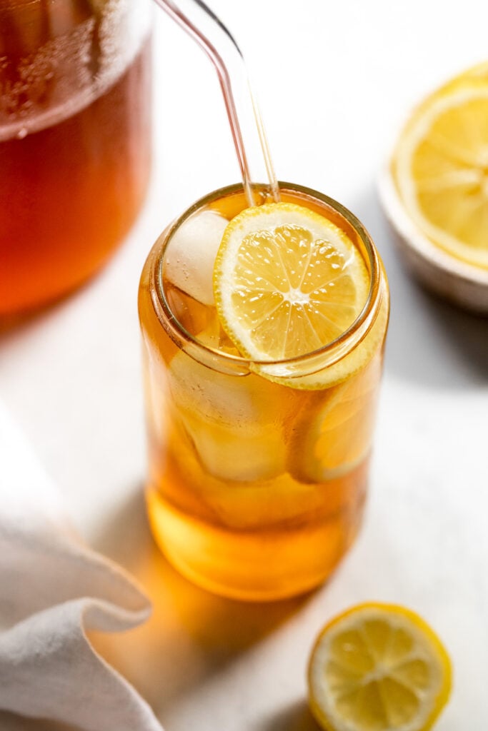 Glass of iced tea with lemon slice and straw.