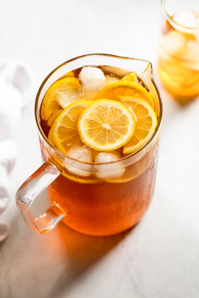 Pitcher of iced tea with lemon slices.
