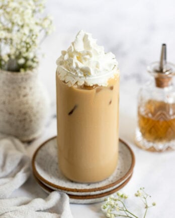 Iced vanilla latte with whipped cream on top.