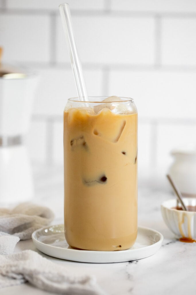 Iced caramel latte in glass with straw.