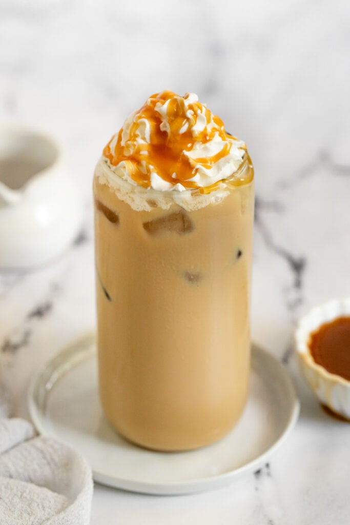 Iced caramel latte with whipped cream and caramel sauce drizzle.