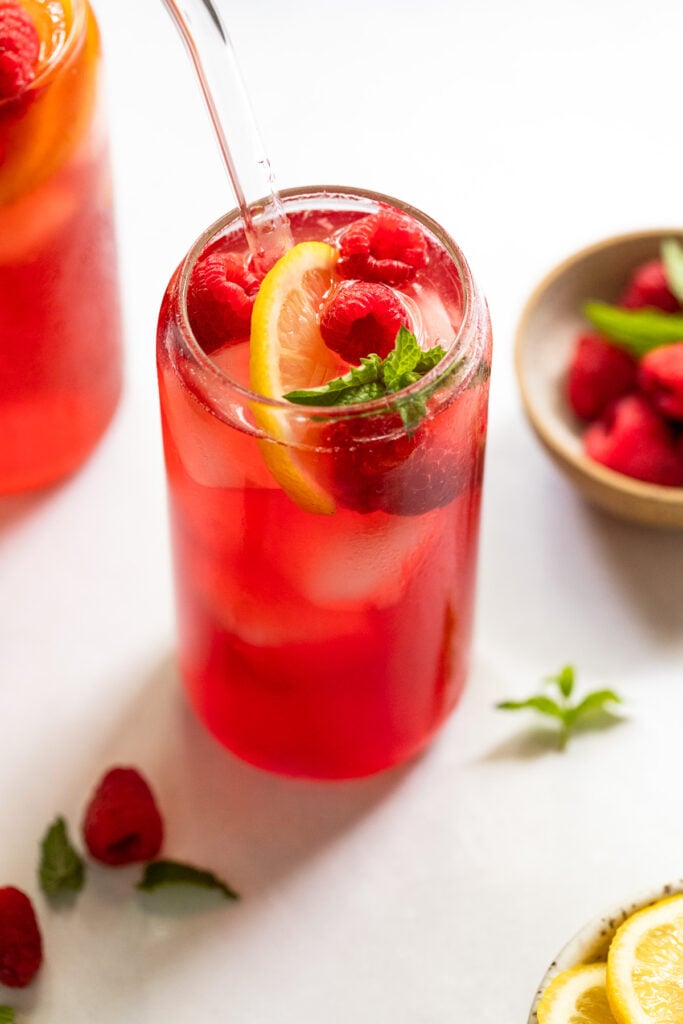 Raspberry iced tea with raspberries, mint, and lemon.