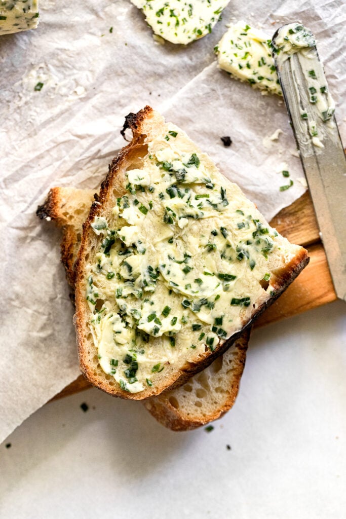 Chive butter spread on slices of sourdough bread.