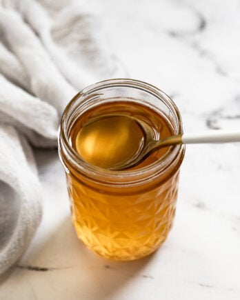 Jar of caramel simple syrup with spoon.