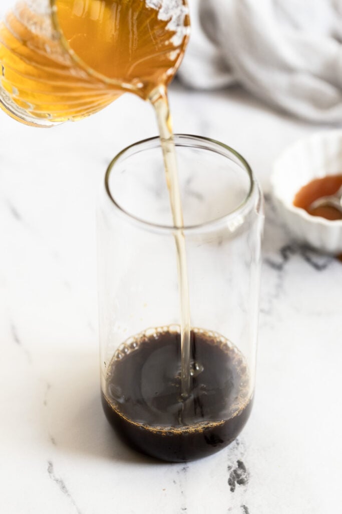Caramel syrup pouring into espresso.