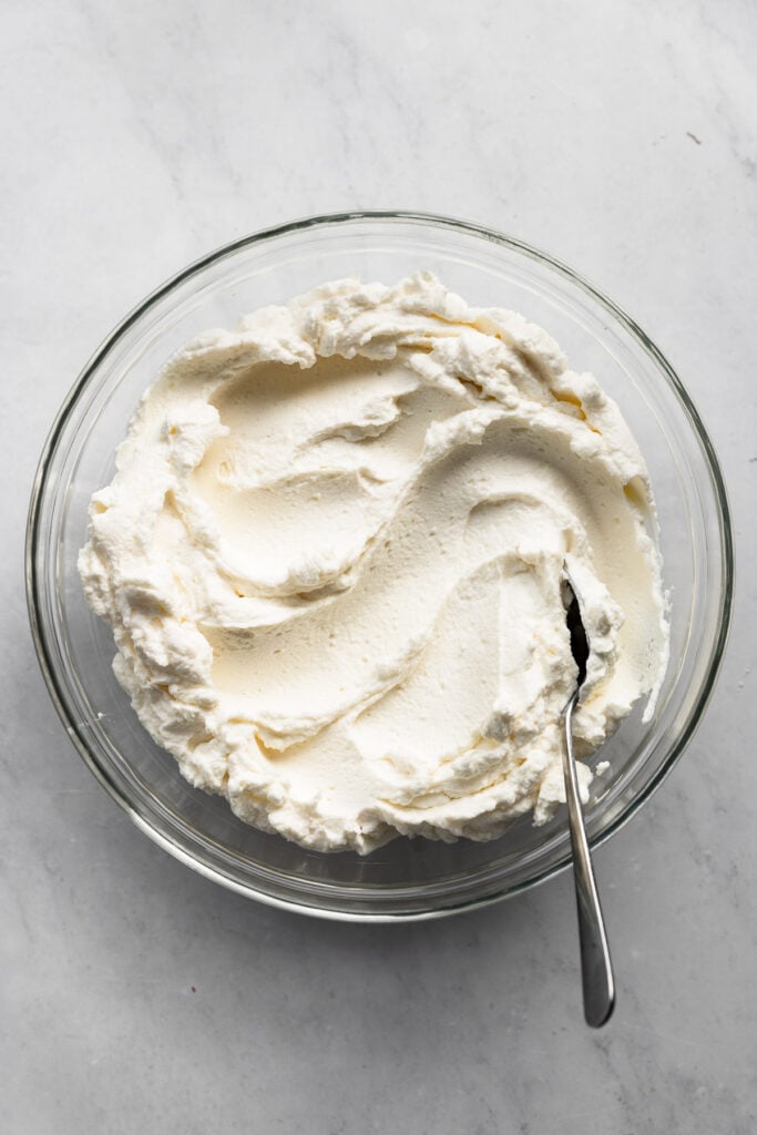 Bowl of whipped ricotta with spoon.