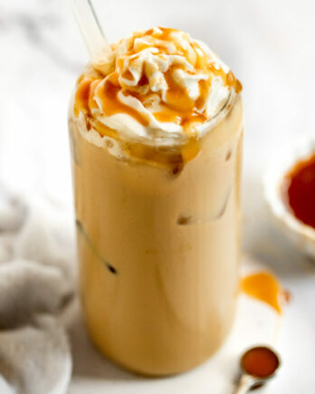 Iced caramel latte with whipped cream and caramel drizzle.