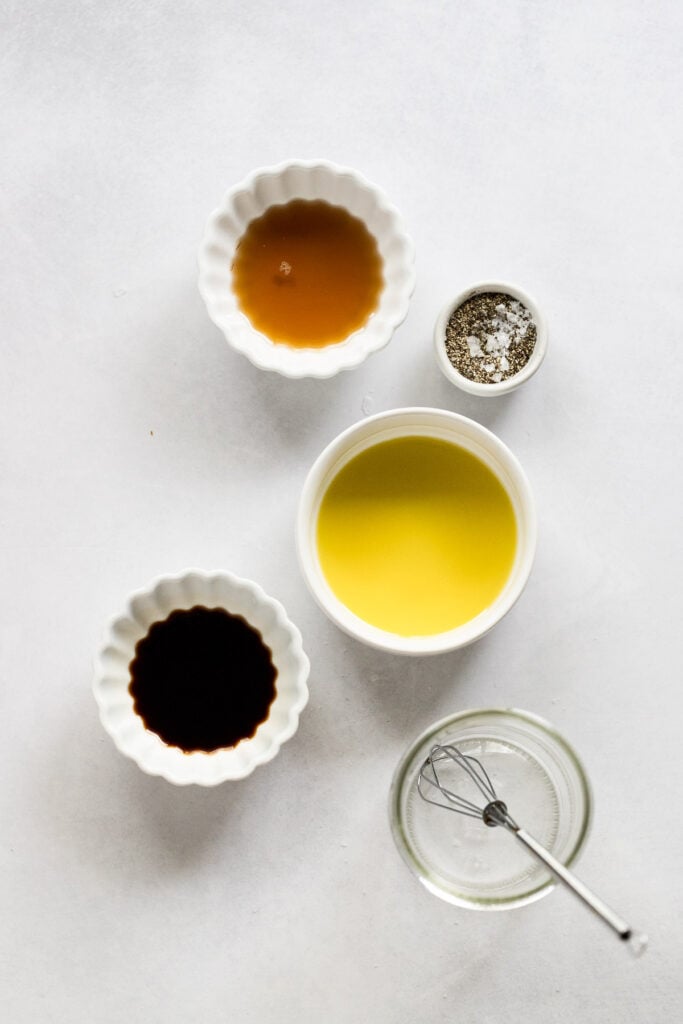 Balsamic vinegar, olive oil, maple syrup, salt and pepper in bowls.