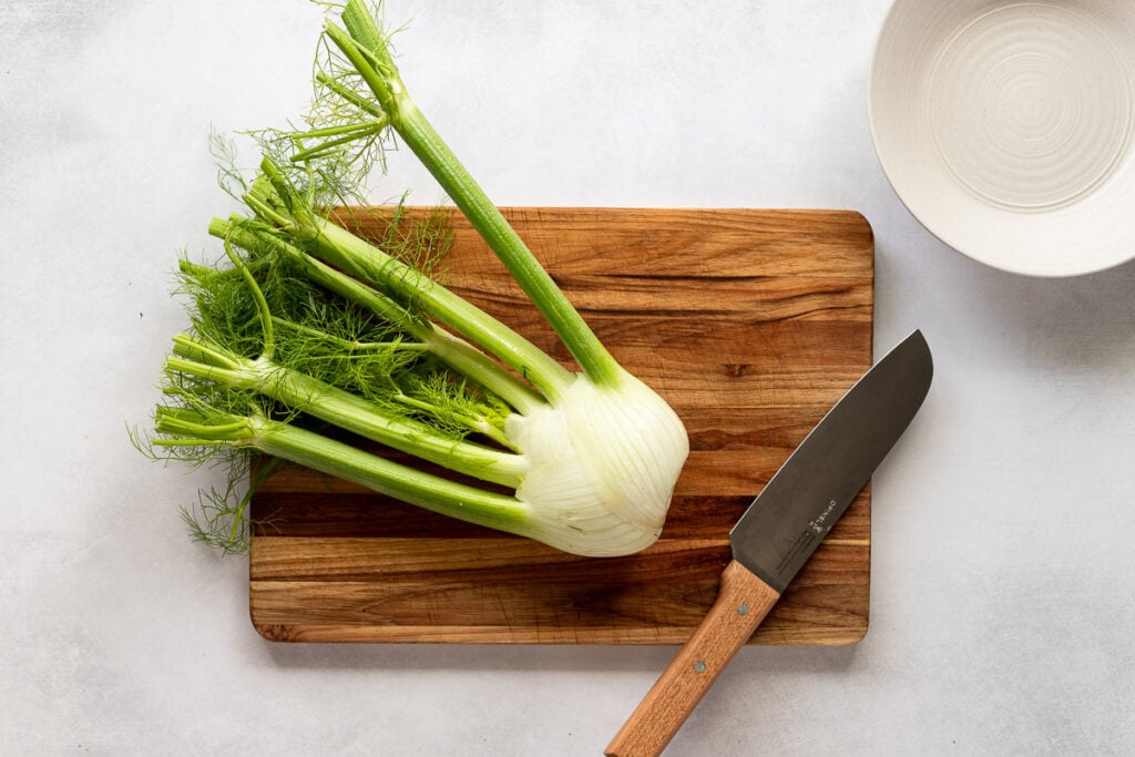 Fennel on cutting board next to knife and bowl.
