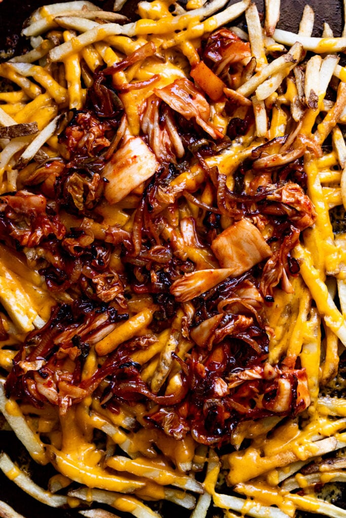 Kimchi and caramelized onions on cheese fries.