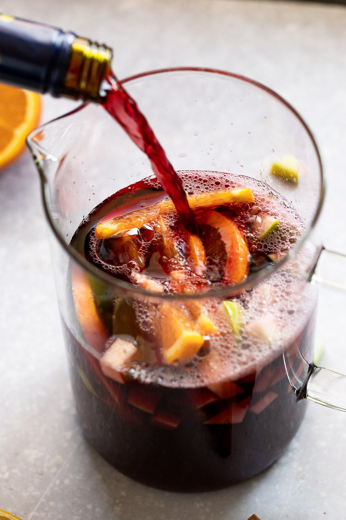 Red wine pouring into sangria pitcher.