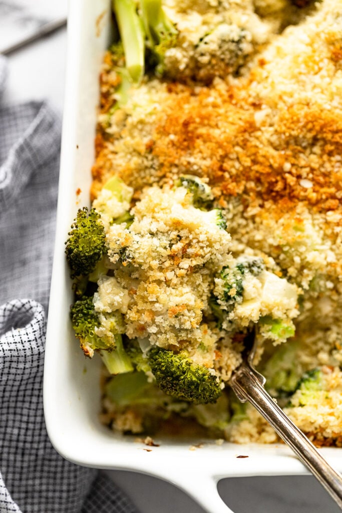 Up close scoop of spoon with broccoli gratin.