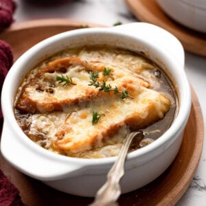 Side view of bowl of french onion soup with spoon.