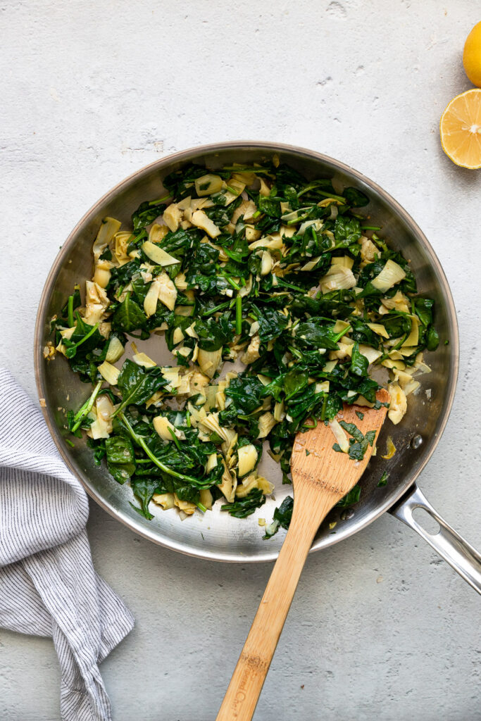 Spinach and artichokes in skillet.