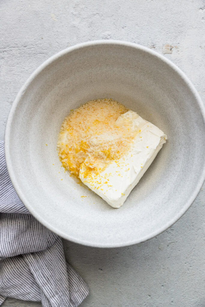Cream cheese, parmesan, and lemon zest in bowl.