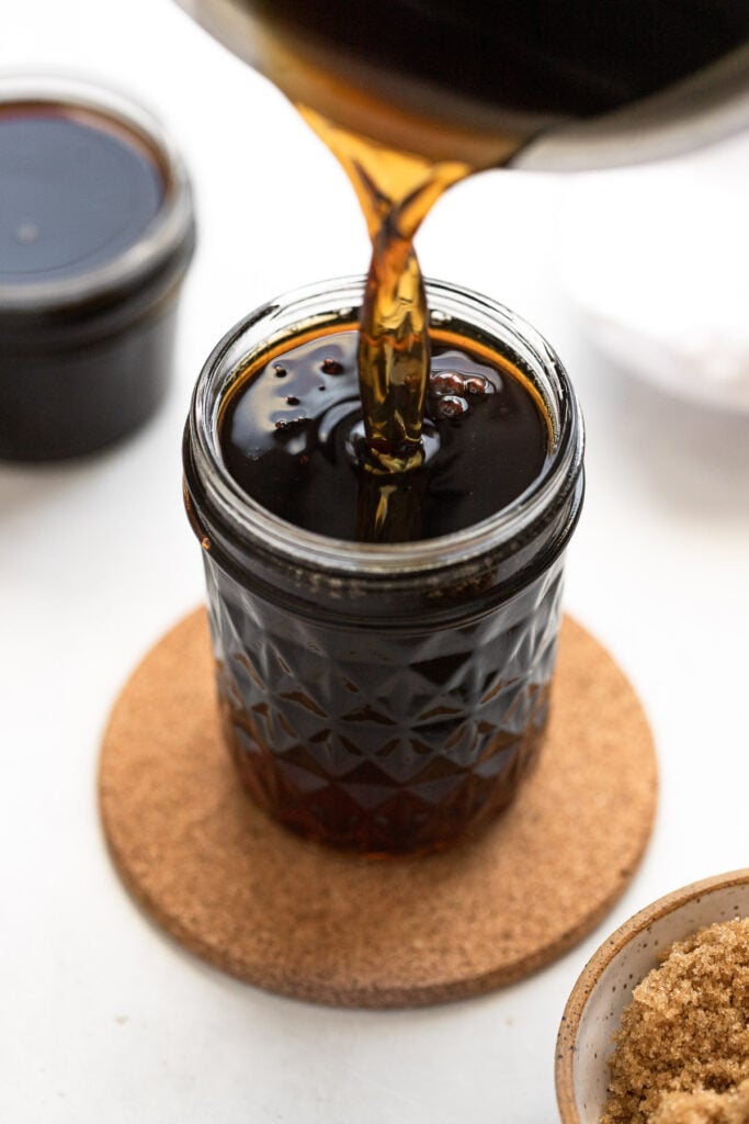 Brown sugar simple syrup pouring into jar.