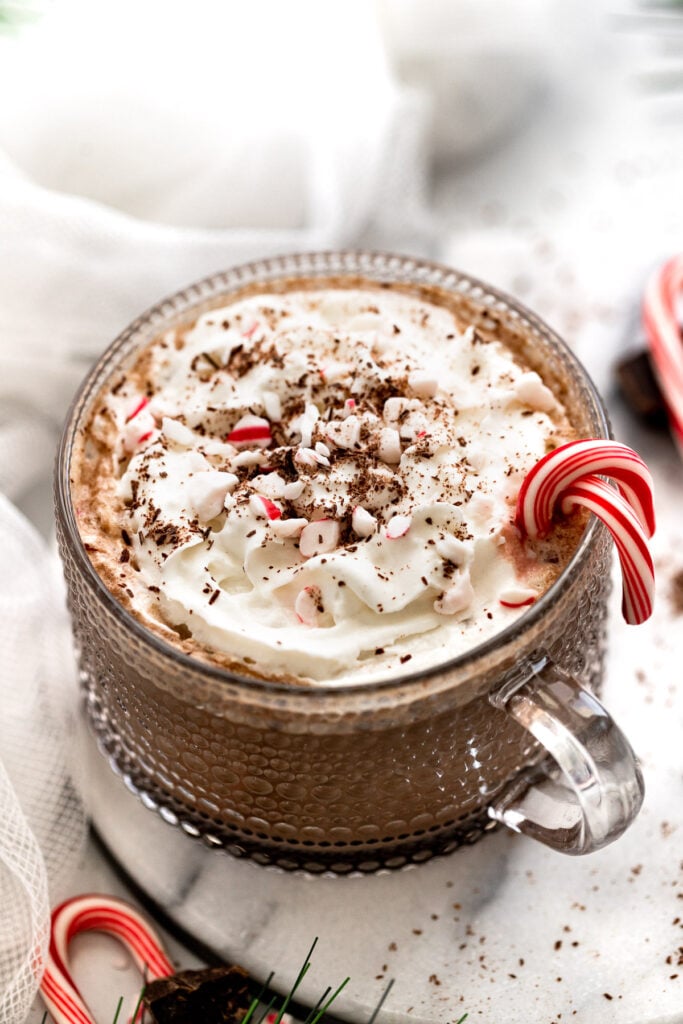 Peppermint mocha with whipped cream and candy canes on tray.
