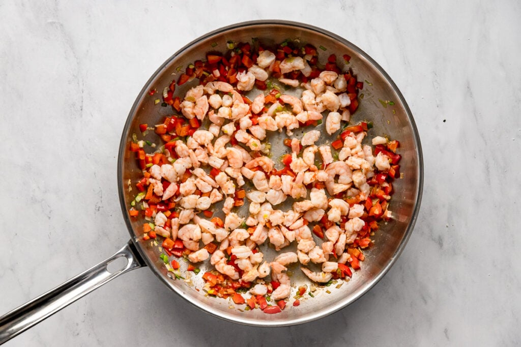 Roughly chopped shrimp in skillet.