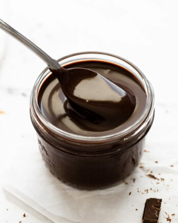 Spoon scooping chocolate syrup.
