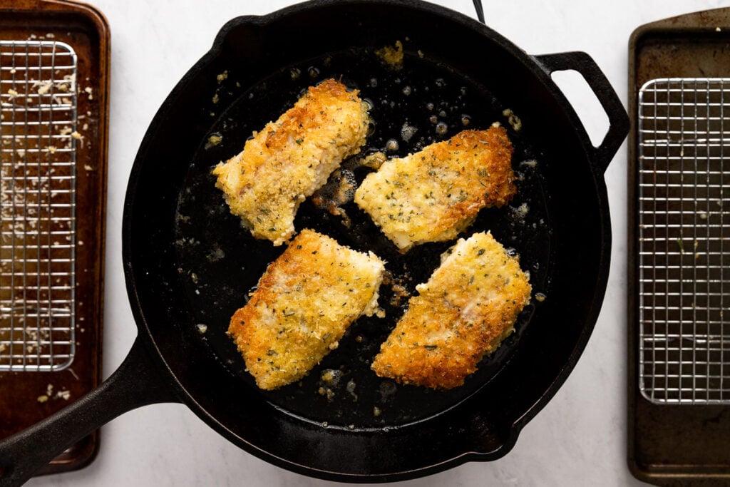 Cast iron skillet with pan-fried fish.
