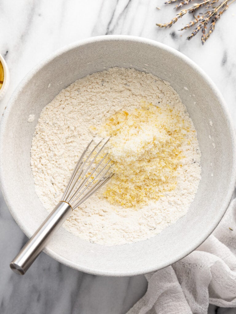 Bowl with dry ingredients and sugar lemon zest mixture with whisk.
