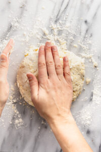 Hands folding dough.