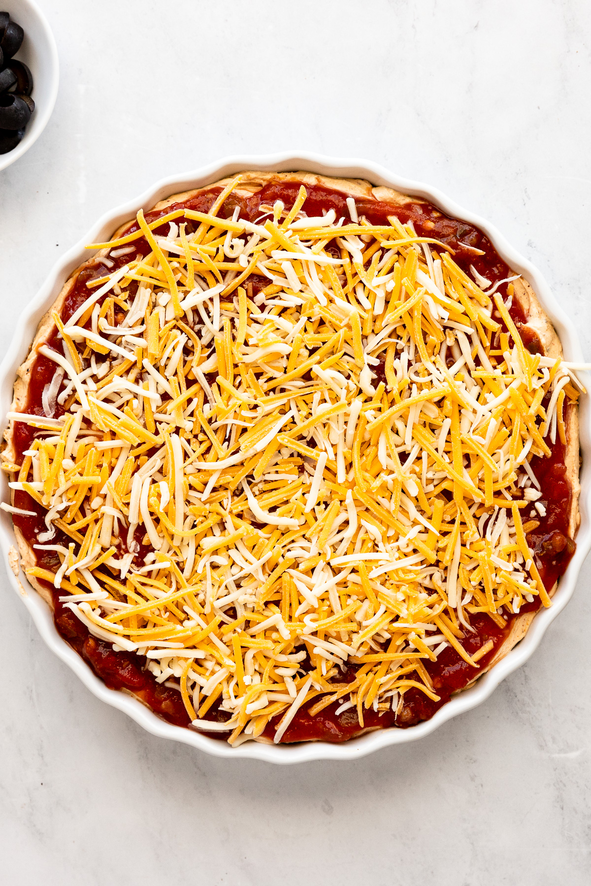 Shredded cheese added to layered dip.