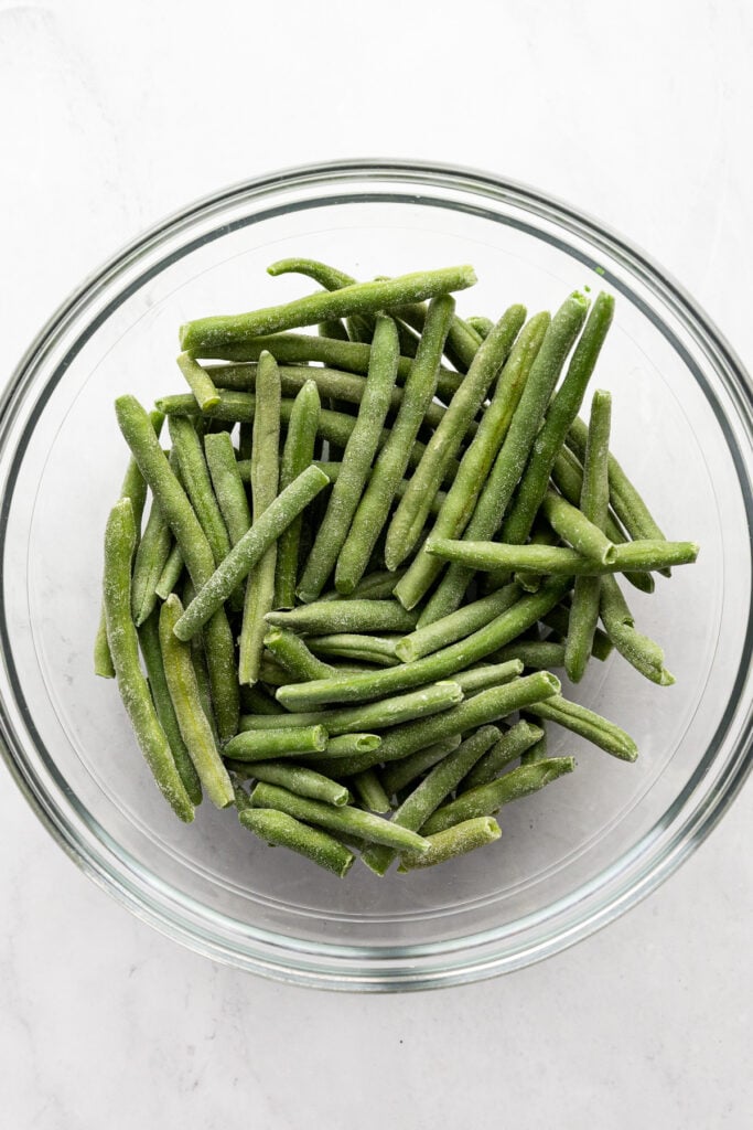 Frozen green beans in glass bowl.