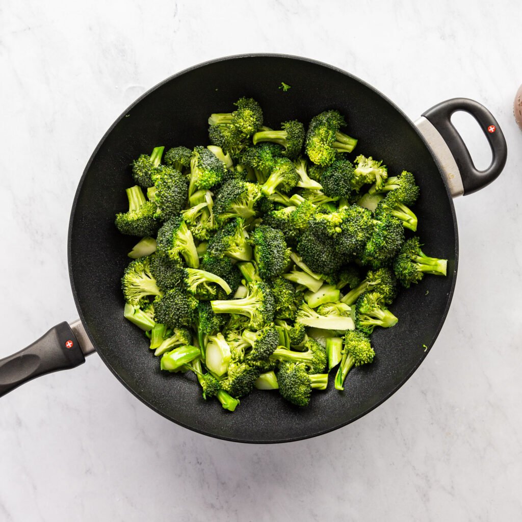 Raw broccoli in wok.