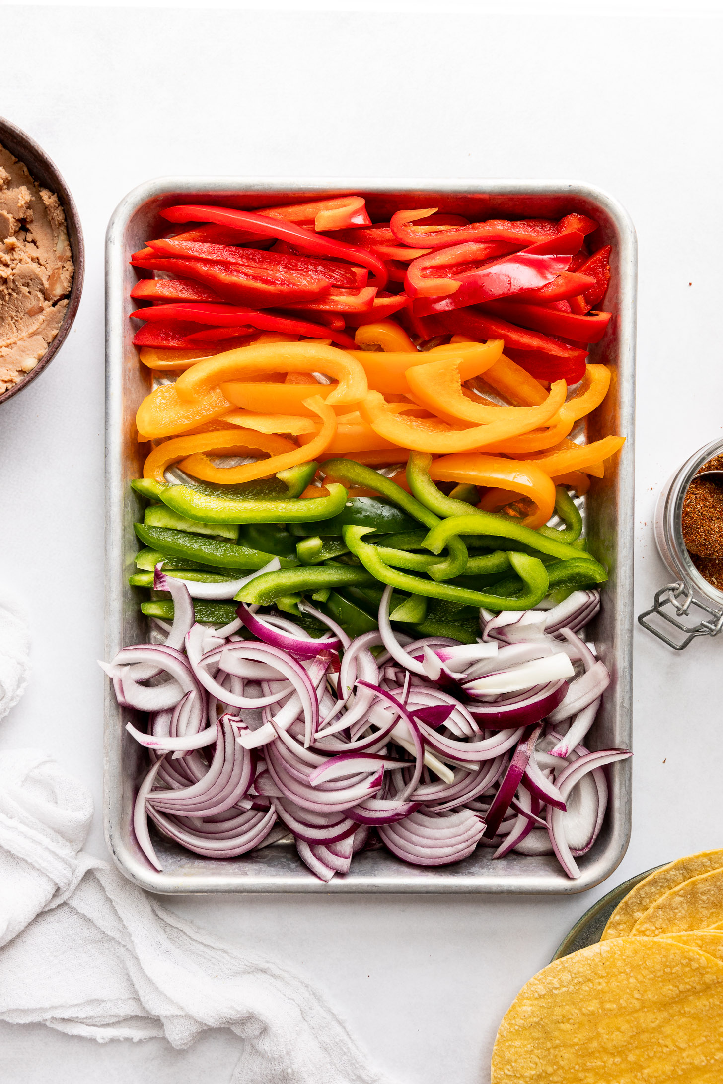 Sheet pan of sliced peppers and onion.