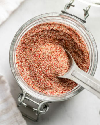 Jar of seasoned salt with measuring spoon.