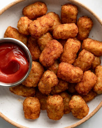 Bowl of tater tots with ketchup.