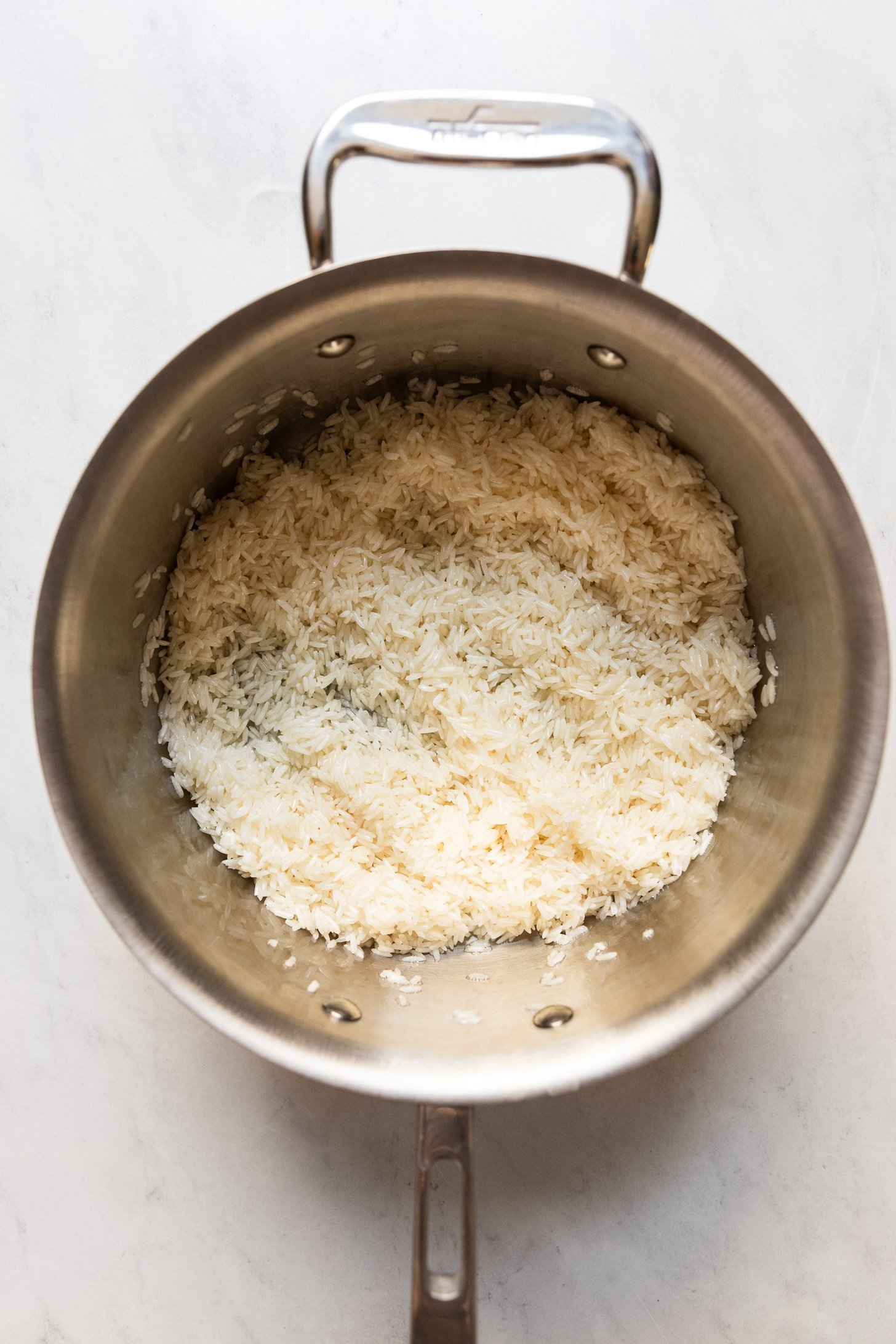 Rice with butter in saucepan.