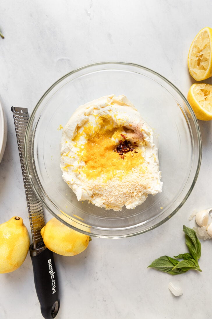 Ricotta with lemon zest and spices in bowl.