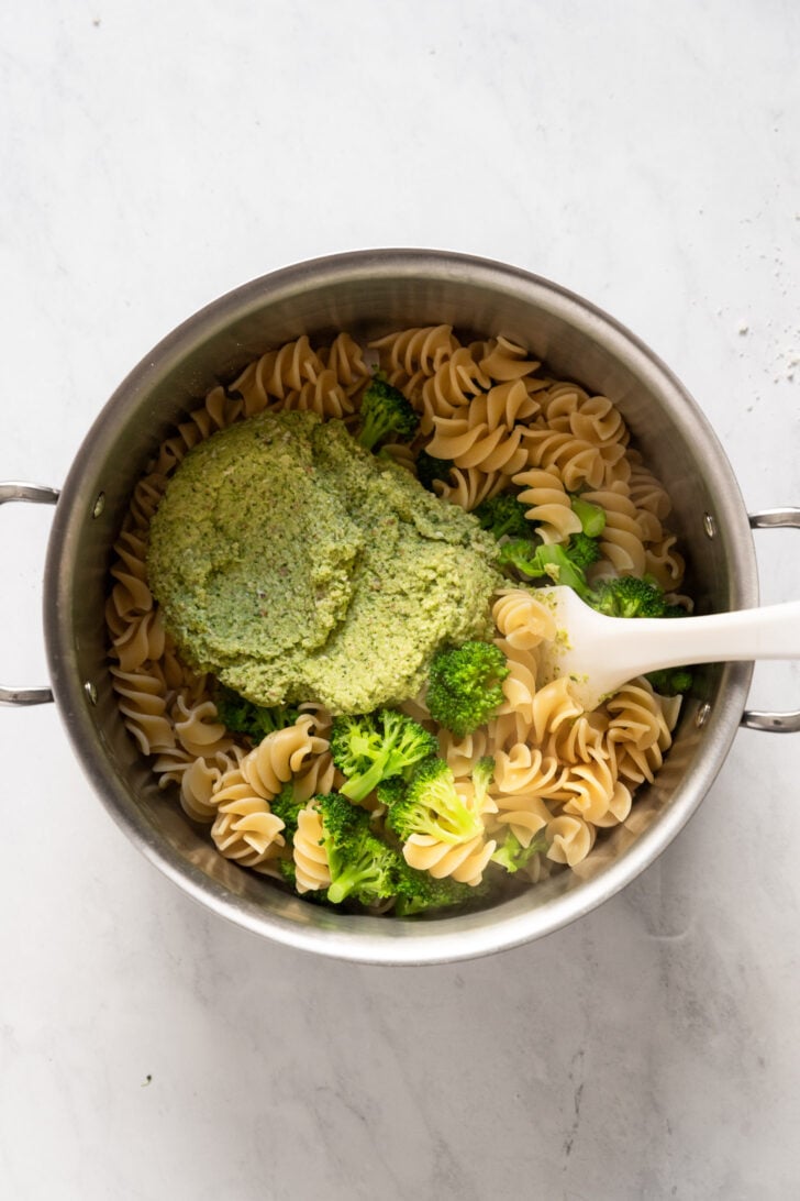 Pesto added to pot with pasta and broccoli.