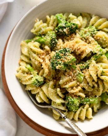 Broccoli pesto pasta in bowl up close with fork.